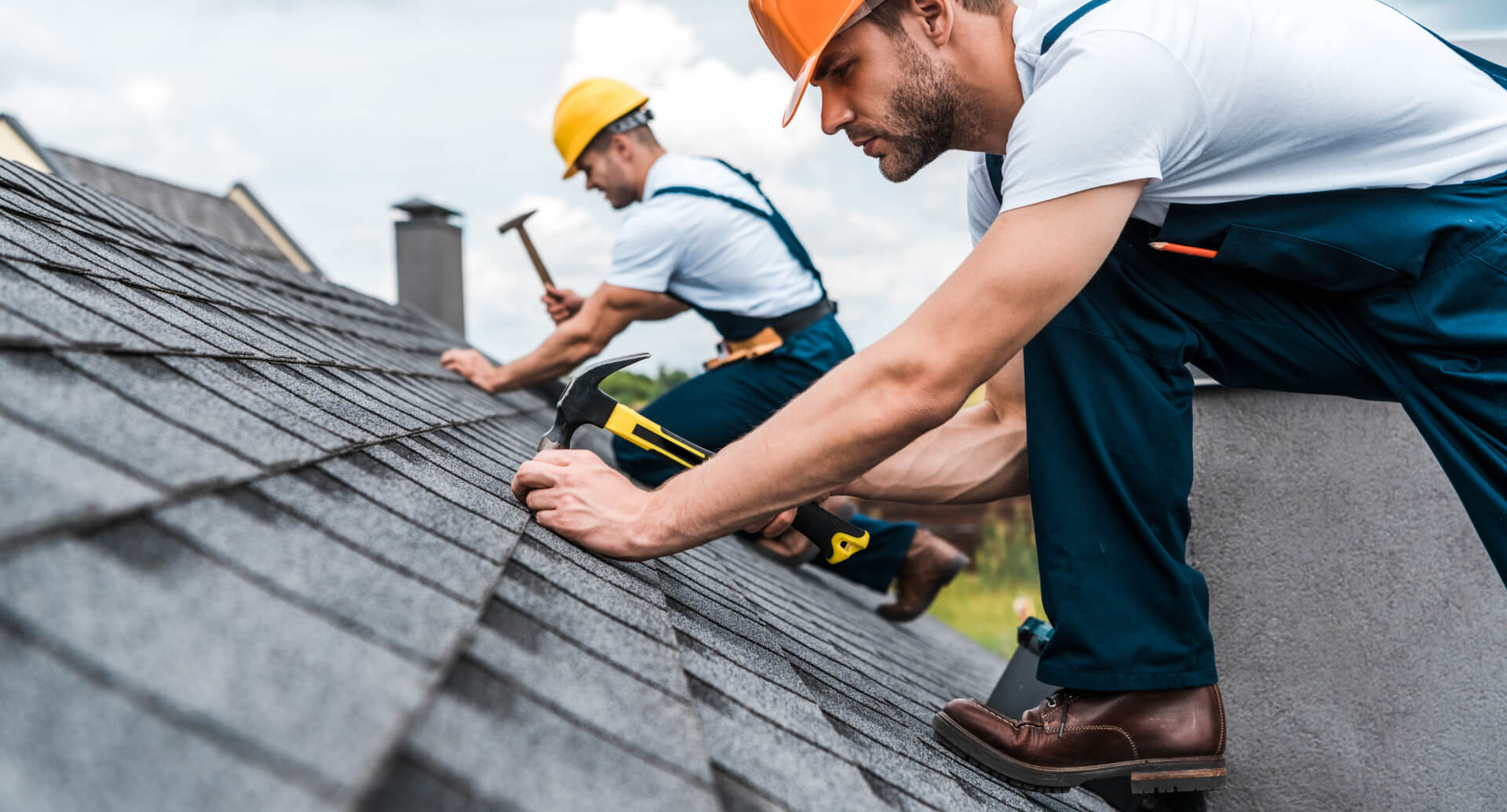 Two L&G roofers nailing down architectural shingles on a residential roof